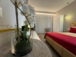 un vaso con fiori bianchi su un tavolo in una camera da letto di MEG Glamour Suite a Milano