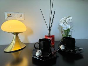 un tavolo con due tazze di caffè nere e una lampada di MEG Glamour Suite a Milano