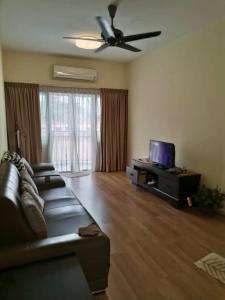 een woonkamer met een bank en een flatscreen-tv bij Sweet Homestay Golden Shower Apartment in Melaka