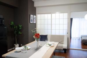 a living room with a table with flowers on it at LN12 Arietta 三ノ宮駅徒歩10分元町エリアの交通至便貸切2DK room in Kobe