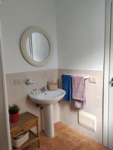 La salle de bains est pourvue d'un lavabo, d'un miroir et de serviettes. dans l'établissement Via Mare, à Ficarazzi