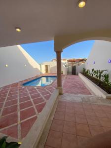 uma vista para uma casa com piscina em فيلا بمسبح خاص و شاطئ رملي في درة العروس em Durat Alarous