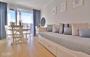 Schlafzimmer mit einem Bett, einem Tisch und Stühlen in der Unterkunft Sunset Apartments - Roosevelta - Premium - Garaż in Świnoujście