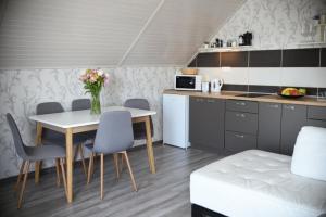 a kitchen with a table and chairs and a table and a kitchen at Crystal Apartman in Mórahalom