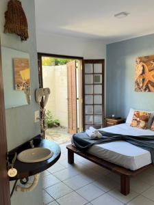 um quarto com uma cama e um lavatório em Pousada Estrela do Mar em Maresias