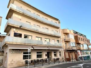 un edificio con mesas y sillas delante de él en Hotel Sancho en Hospitalet de l'Infant