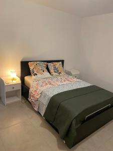 1 dormitorio con 1 cama y mesa auxiliar en Villa callinajo 1 T3 , 6 places Clim à 1 min de la plage, en Belgodère
