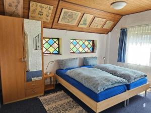 ヴェスターラントにあるGrenzhof-Blumenwohnungのベッドルーム1室(青い掛け布団付きのベッド1台付)