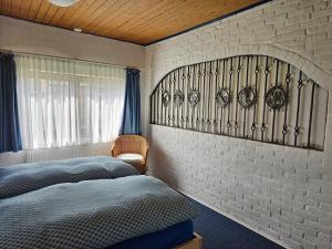 ヴェスターラントにあるGrenzhof-Blumenwohnungのレンガの壁、ベッド2台が備わるベッドルーム1室が備わります。