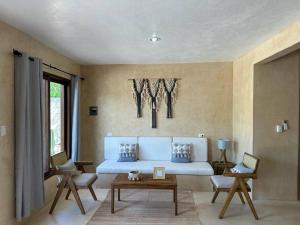 a living room with a white couch and a table at María Amor- Contemporary Maya Oasis in Valladolid