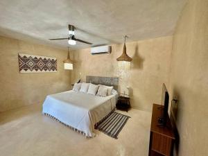 a bedroom with a bed and a television in it at María Amor- Contemporary Maya Oasis in Valladolid