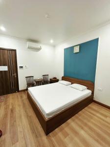 a bedroom with a large bed with a blue wall at Đình Vũ 3 Motel in Hai Phong