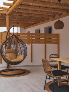 a hanging chair in a room with a table and chairs at Alonia Suites in Naousa