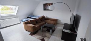 a living room with a couch and a television at Urlaub am Rhein Speyer Hockenheim in Altlußheim