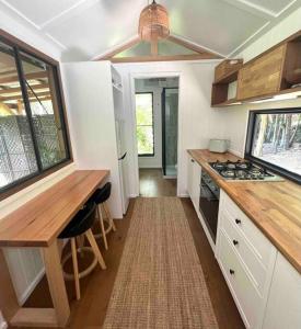 a kitchen with a table and a stove top oven at Whispering Palms, Luxury Tiny Home in Crabbes Creek