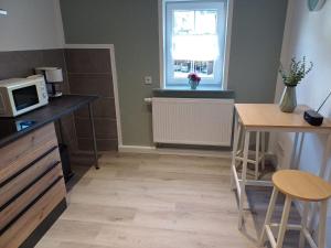 a small kitchen with a microwave and a table at Ferienwohnung Schwibbogen in Drebach