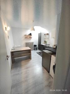 eine kleine Küche mit weißen Wänden und Holzböden in der Unterkunft Urlaub am Rhein in Altlußheim