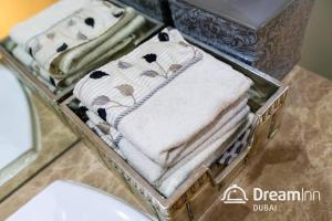 - un plateau avec des serviettes sur un comptoir dans la salle de bains dans l'établissement Dream Inn - Contemporary 2BR Marsa Tower, à Dubaï