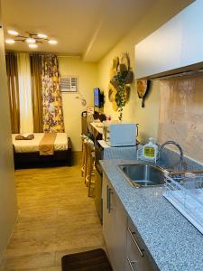 cocina con fregadero y habitación con cama en Pauline's Getaway near Nuvali Paseo Santa Rosa en Bayabasan
