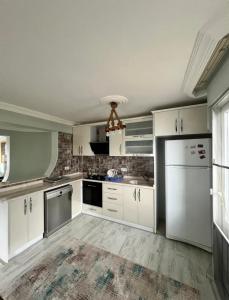 an empty kitchen with white cabinets and appliances at Dublex havuzlu villa in Erdemli