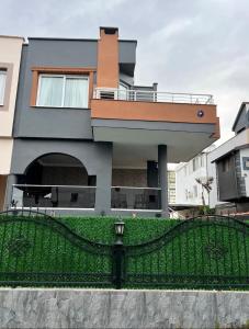 une maison avec une clôture noire devant elle dans l'établissement Dublex havuzlu villa, à Erdemli