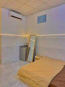 Habitación con cama y espejo en la pared. en Homestay Tuyết Trinh en Nha Trang