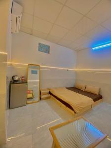芽莊的住宿－Homestay Tuyết Trinh，一间小卧室,配有一张床和蓝色的灯光