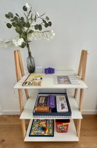 una mesa con un estante con libros y un jarrón en Plaza Tomás en Pamplona