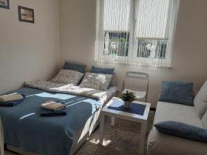 a small bedroom with a bed and a couch at Villa Spokojna 26 in Mielno