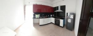 a small kitchen with red cabinets and a refrigerator at Teddy Bear Home in Birkhadem