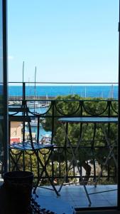 a balcony with a table and a view of the ocean at Nene's Home in Sanremo
