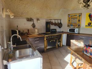 a kitchen with a sink and a stove at La grotte in Bourré +12 photos
