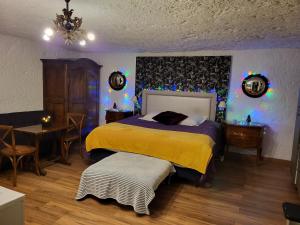 a bedroom with a bed and a table and a chair at La grotte in Bourré