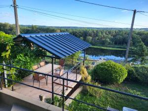 a house with a blue roof with a view of a lake at La grotte in Bourré