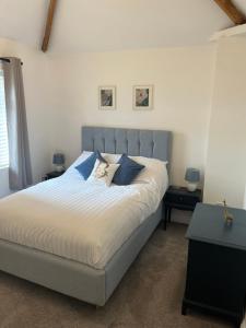 una camera da letto con un grande letto con cuscini blu di Bonny Cottage a Whitby