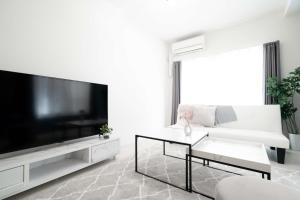 sala de estar blanca con TV de pantalla plana grande en 12名可!三宮中心地、便利さ抜群、快適LUXテイストマンション, en Kobe