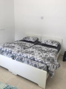 a bed with two pillows on it in a bedroom at Appartement Les Cyclamens Hammam-lif Tunisie Afrique in Hammam-Lif