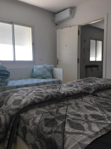 een slaapkamer met een bed en een raam bij Appartement Les Cyclamens Hammam Lif Tunisie in Hammam-Lif