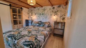a bedroom with a bed with a colorful comforter at Domaine du Raysse in Saint-Cirq