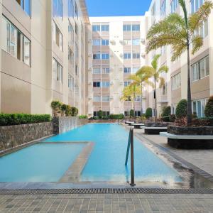 a swimming pool in front of a building at Condo in Silang near Nuvali - Dy's Haven Suites in Silang