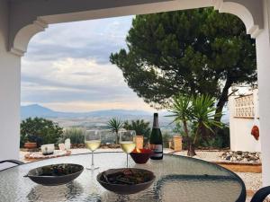 - une table avec deux verres de vin et un bol de nourriture dans l'établissement Casa del Barco with pool and stunning views, à Guaro