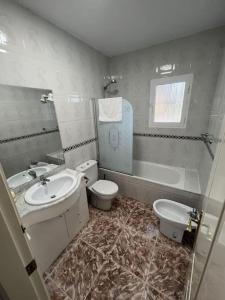 La salle de bains est pourvue d'un lavabo, de toilettes et d'une baignoire. dans l'établissement Casa del Barco with pool and stunning views, à Guaro