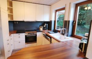 a kitchen with white cabinets and a sink at Feriendomizil am Rössleberg, Hinterzarten in Hinterzarten