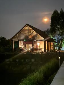 a house with a large glass facade at night at Mayuree Homestay in Kranuan