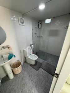 ein Bad mit einer Dusche, einem WC und einem Waschbecken in der Unterkunft Mayuree Homestay in Kranuan