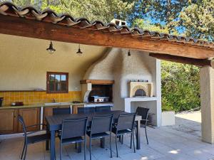 an outdoor kitchen with a table and chairs in a house at La Luberonne in Lourmarin