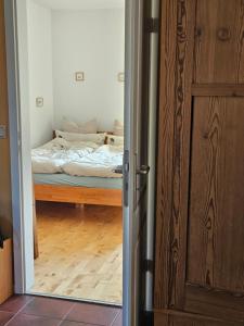 Una puerta que conduce a un dormitorio con cama en Ferienzimmer im Grünen, Privatunterkunft, en Dötlingen