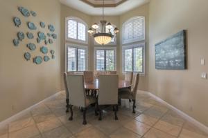 a dining room with a table and chairs and a chandelier at Royal Palm House in Captiva +33 photos