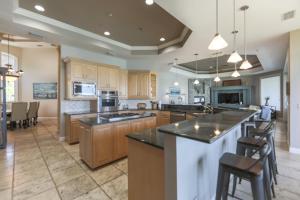 Royal Palm House في كابتيفا: مطبخ كبير مع دواليب خشبية وجزيرة كبيرة