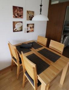 a dining room table with four chairs and aendant light at Kurhotel Schluchsee App 2313 - Genießer-Apartment mit Südbalkon - mit Indoorpool Schluchsee, Hochschwarzwaldkarte in Schluchsee